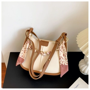 Detail of cream and brown crossbody bag featuring a pink animal print scarf and chain strap