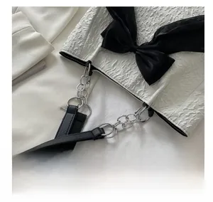 Détail du nœud en satin noir et de la texture plissée sur ce sac cabas blanc