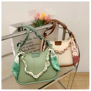 Detailed view of stylish bucket bags in light green and cream with silk scarf handles