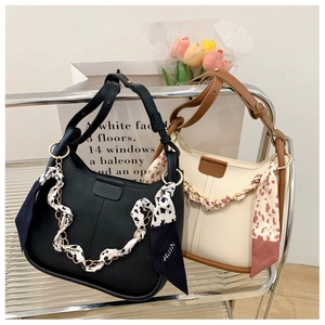 Detail of hobo bags with silk scarf wrapped chain and elegant vertical stitching