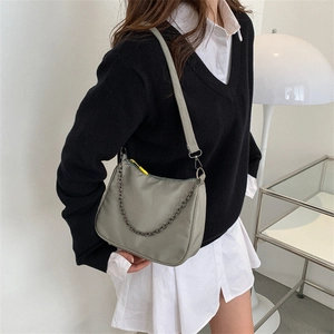 Minimalist grey nylon crescent bag with adjustable strap and decorative metal chain