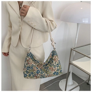 Detail of floral embroidery on canvas shoulder bag with unique knotted rope strap