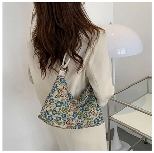 Detailed texture of vintage jacquard fabric with floral embroidery on a retro shoulder bag