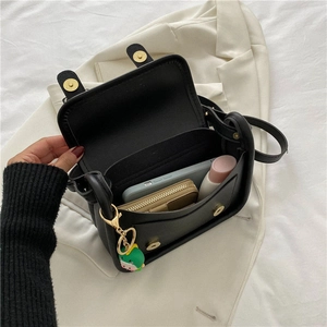 Chic black crossbody underarm bag with gold hardware and dinosaur charm shown open