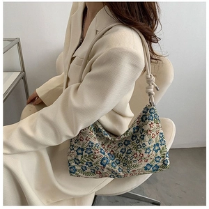 Detailed view of vintage floral jacquard shoulder bag with knotted strap on model