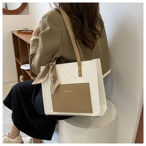 Détail du sac cabas à carreaux avec poche marron contrastante et accessoire foulard