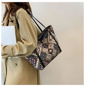 Detail of bohemian woven tote bag showing colorful geometric patterns and leather straps