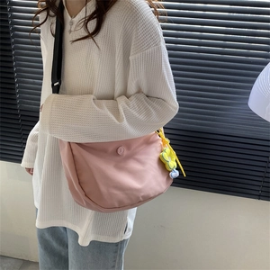 Pink crescent crossbody bag made of smooth nylon with adjustable strap and floral charm