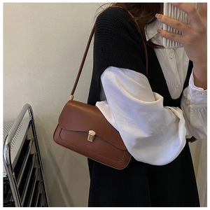 Brown leather saddle bag featuring a gold metal buckle and vintage shoulder strap design
