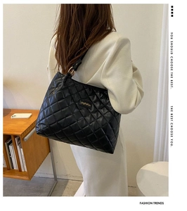 Détail du grand sac cabas noir matelassé avec losanges et anneaux dorés élégants