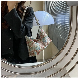 Detail of floral jacquard hobo bag with unique knotted leather strap and zipper closure