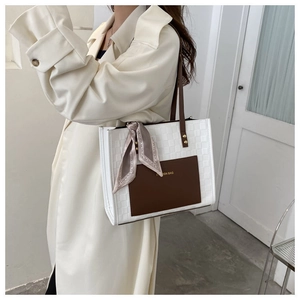 Détail du sac cabas en cuir tressé blanc avec bandoulières marron et foulard en soie