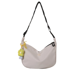 Minimalist beige dumpling crossbody bag with adjustable strap and floral charm