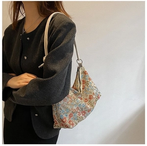 Detail of vintage floral jacquard hobo bag with braided rope strap on model