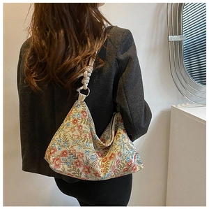 Detail of vintage floral jacquard shoulder bag with braided white rope handle