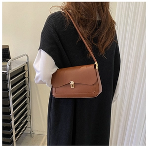 Close-up of a vintage brown leather shoulder bag with a gold rectangular metal lock