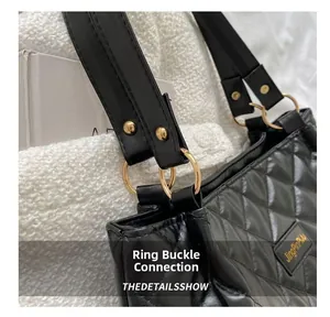 Détail du fermoir doré sur un sac cabas matelassé noir avec texture cousue
