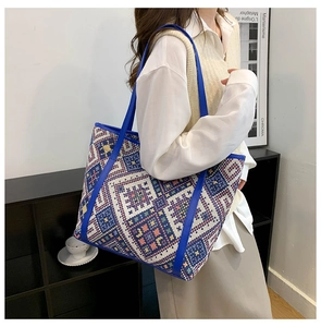 Close-up of woven geometric diamond pattern on large blue canvas tote bag