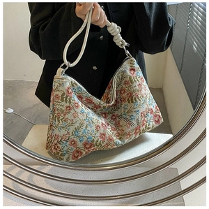 Detail of floral tapestry handbag with white leather knotted shoulder strap and vintage pattern