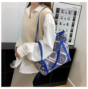 Detail of colorful geometric canvas tote bag with vibrant blue shoulder strap and large capacity
