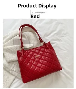Détail du sac cabas matelassé rouge avec ferrures dorées et plaque de marque en métal