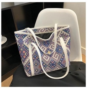 Close-up of geometric woven pattern and canvas texture on large tote bag with white straps