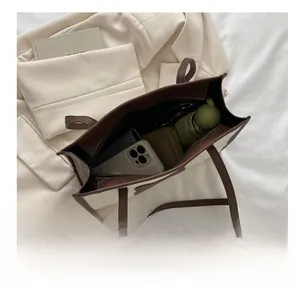 Spacious tote bag interior showing daily items like phone, umbrella, and books
