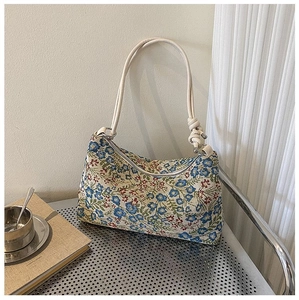 Detailed shot of retro floral jacquard underarm bag with unique knotted strap design