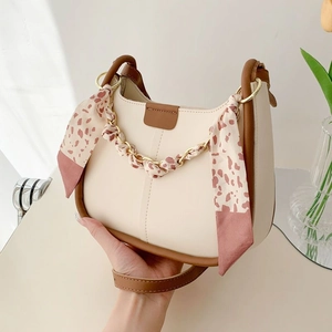 Fashionable beige and brown bucket bag with floral scarf and gold chain detail
