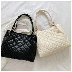 Détail de grands sacs cabas matelassés en noir et beige avec coutures élégantes