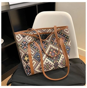 Close-up of geometric woven canvas tote bag with brown leather handles and inner lining