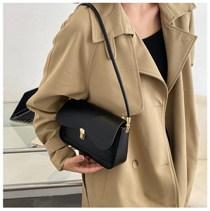 Detail view of a vintage black saddle bag featuring a sleek gold buckle and premium leather
