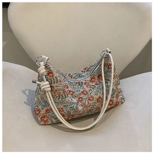 Detail of floral jacquard hobo bag with colorful embroidery and knotted shoulder strap