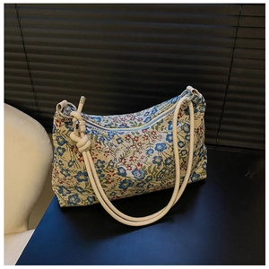 Close-up of floral jacquard fabric and cream knotted leather strap on vintage underarm bag