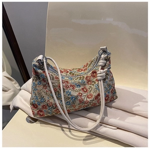 Detail of vintage floral jacquard fabric and ivory leather strap on retro shoulder bag