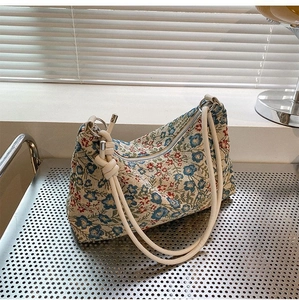 Detail of floral jacquard canvas hobo bag with knotted strap and wavy edge design