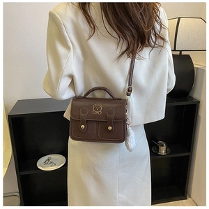 Detailed back view of vintage brown mini crossbody bag with cute bear charm and plush pendant