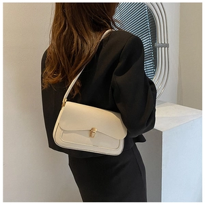 Detail of minimalist cream-white shoulder bag featuring a gold buckle and U-shaped stitching