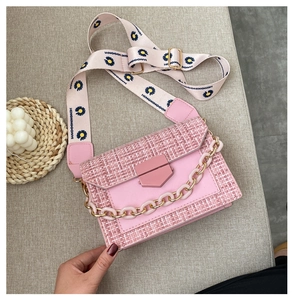 Detail of pink tweed crossbody bag with daisy strap and decorative acrylic chain