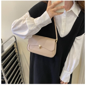 Beige faux leather saddle bag with gold swivel lock shown on a model for daily style