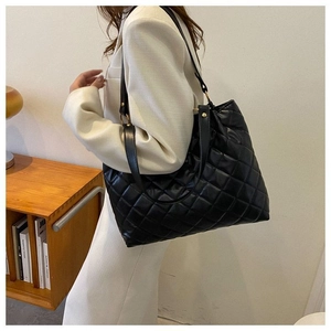Détail d'un grand sac cabas matelassé noir avec bandoulière pour femme élégante