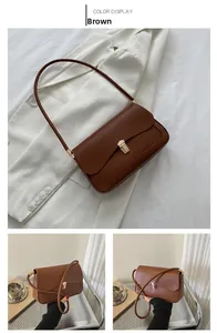 Macro detail of brown leather shoulder bag featuring a polished gold metallic buckle closure