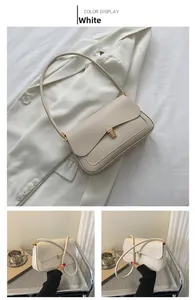 Close-up of cream white saddle bag with golden metal buckle and fixed shoulder strap