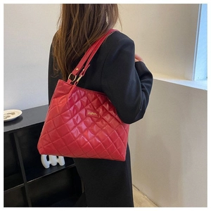 Vue latérale de ce sac cabas matelassé rouge avec détails dorés sur un blazer