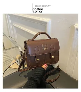 Detail showing vintage coffee PU leather crossbody bag with golden bear logo and buckles