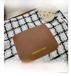 Détail du sac fourre-tout en toile à carreaux avec poche en cuir et pendentif tigre