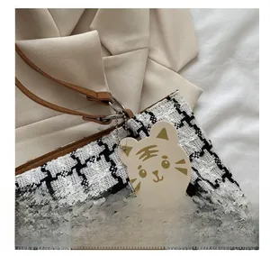 Détail du sac cabas en toile à carreaux avec bandoulière en cuir et charm tigre