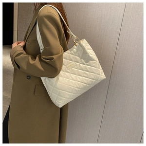 Détail du sac cabas blanc à surpiqûres en losanges avec des finitions dorées