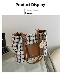 Gros plan sur le sac fourre-tout en tweed noir et blanc avec poche en cuir marron et bijou