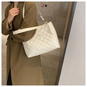 Vue détaillée d'un sac cabas matelassé blanc avec surpiqûres losanges et étiquette